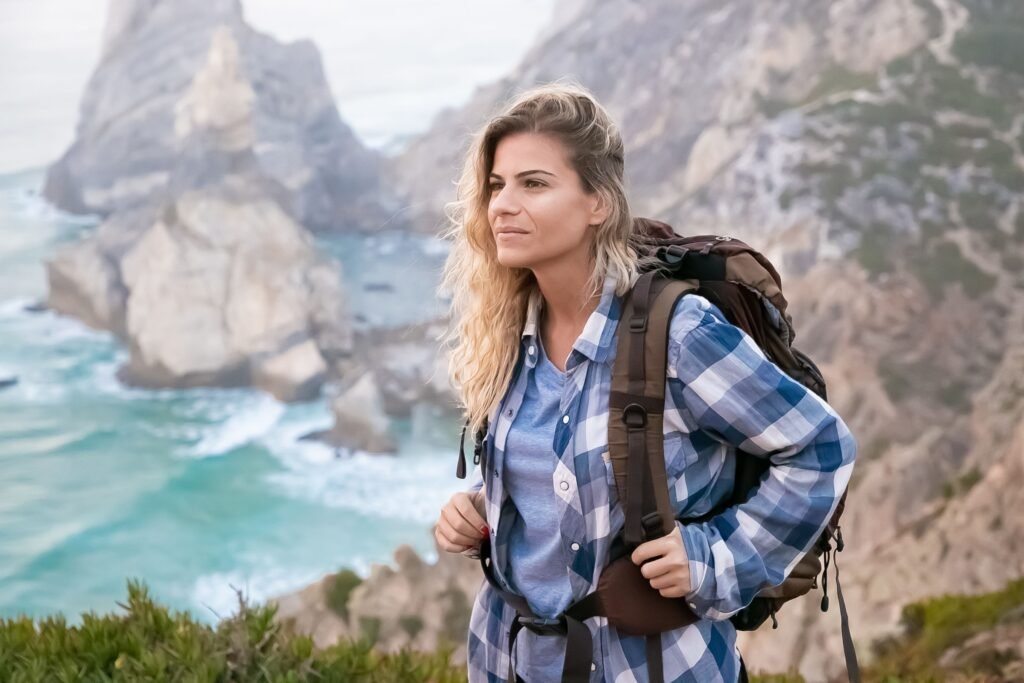 Woman with a backpack hiking along sea cliffs
