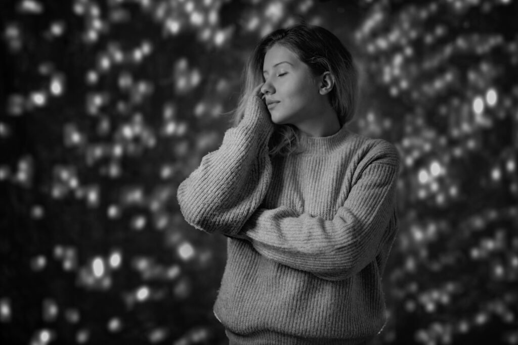 Calm young woman with eyes closed in a cozy sweater, quieting her mind to stop overthinking