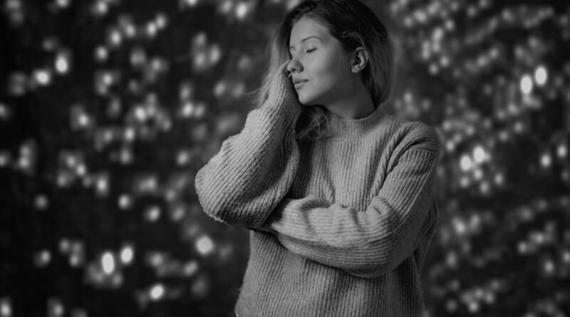 Calm young woman with eyes closed in a cozy sweater, quieting her mind to stop overthinking