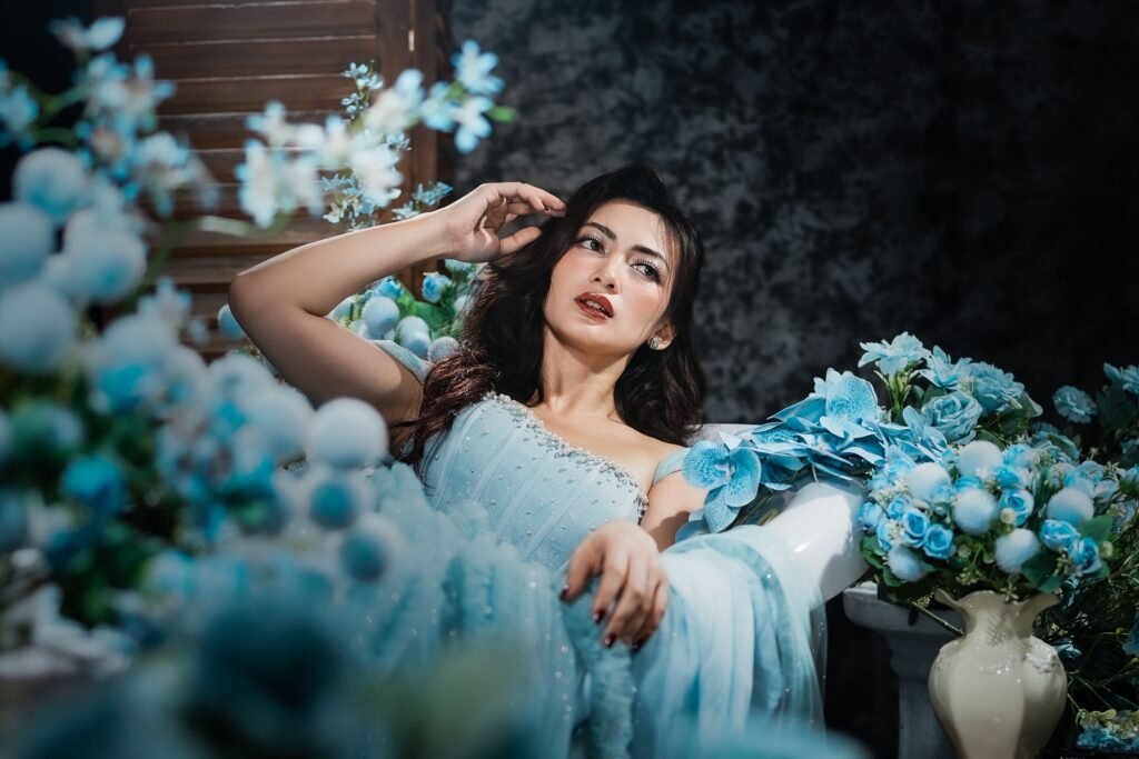Woman in a light blue dress surrounded by blue flowers, showing the meaning of blue color