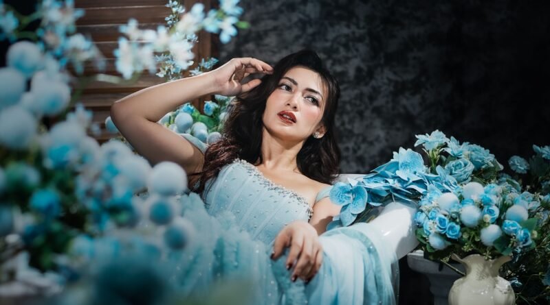 Woman in a light blue dress surrounded by blue flowers, showing the meaning of blue color