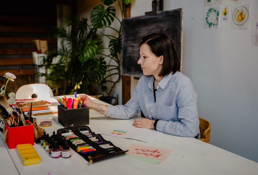 Woman working at a tidy desk in a bright room with plants