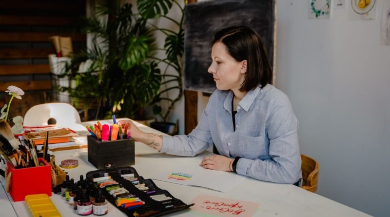 Woman working at a tidy desk in a bright room with plants